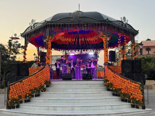 People wearing bright Cinco de Mayo shirts enjoying a lively party with music and friends.