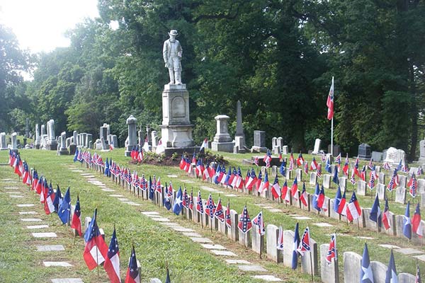 A historical cemetery scene reflecting Confederate Memorial Day 2026 with graves decorated with flowers and flags in quiet remembrance